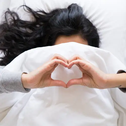 Resident making heart shape with hands in fresh linens